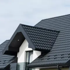 Nowoczesny dach z ciemnoszarej dachówki cementowej. Sprawdź, jaka jest dachówka cementowa cena za m2, by zaplanować remont.