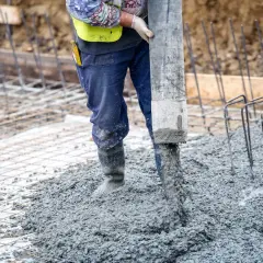 Robot wylewa beton na zewnątrz, tworząc solidną wylewkę betonową.