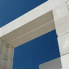Białe nadproże nad drzwiami 90 cm, wykonane z bloczków z betonu komórkowego, na tle błękitnego nieba.