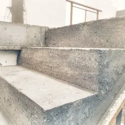 Schody betonowe w trakcie budowy. Widać surowy beton i formę, która jest szalunkiem.