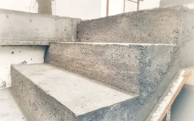 Schody betonowe w trakcie budowy. Widać surowy beton i formę, która jest szalunkiem.