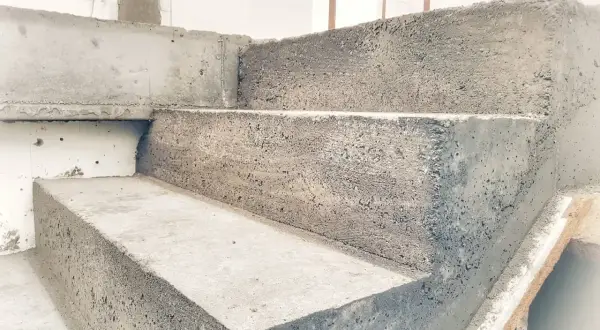 Schody betonowe w trakcie budowy. Widać surowy beton i formę, która jest szalunkiem.