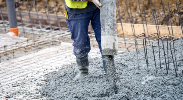 Robot wylewa beton na zewnątrz, tworząc solidną wylewkę betonową.