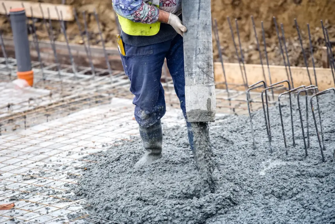 Robot wylewa beton na zewnątrz, tworząc solidną wylewkę betonową.