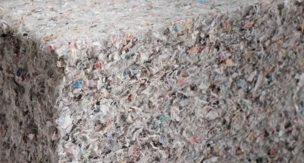 Gęsta, zbita masa z recyklingu, gdzie widać fragmenty kolorowych papierów i włókien. To ekologiczna celuloza, która może zyskać nowe życie.