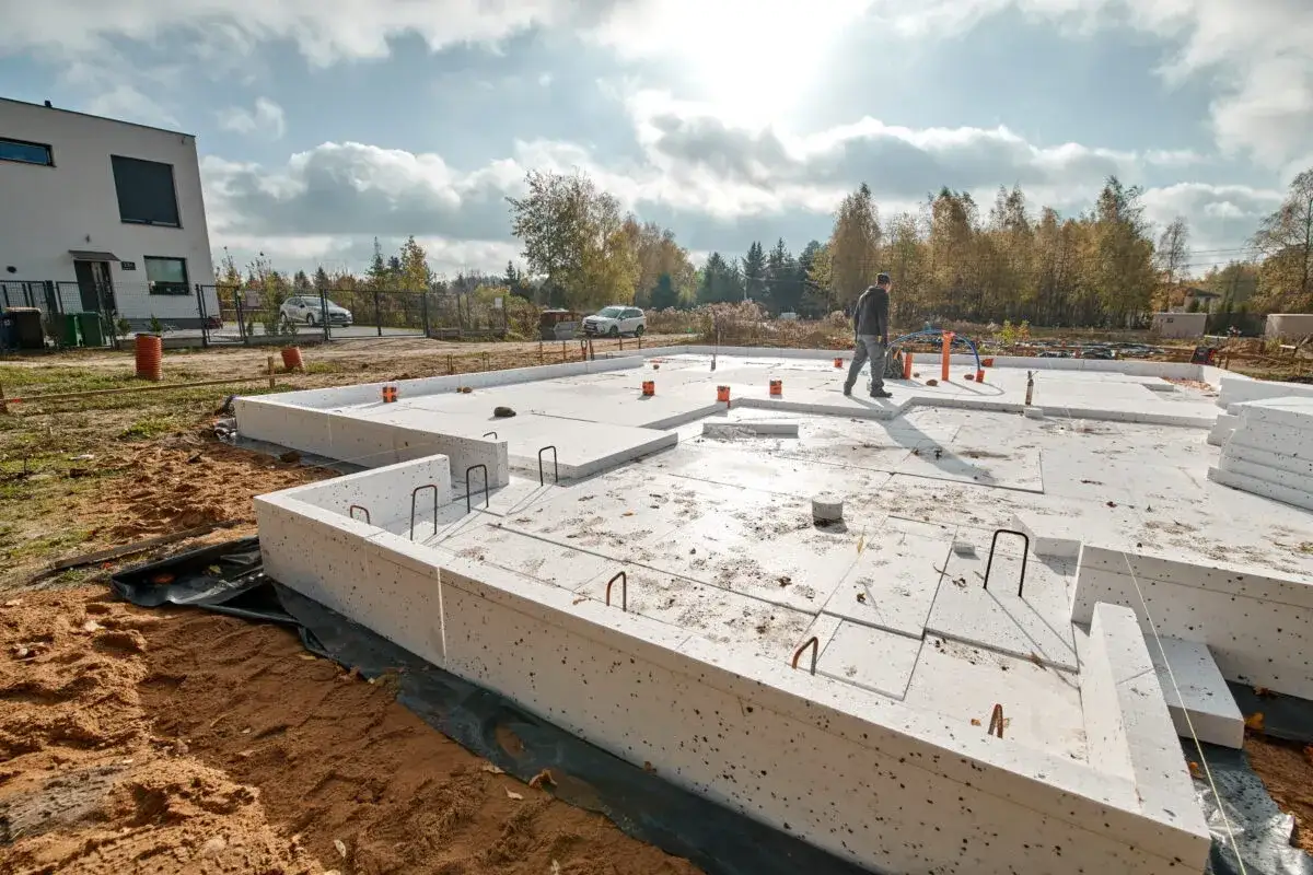 Płyta fundamentowa pod garaż w trakcie budowy. Widać elementy izolacji i zbrojenia.