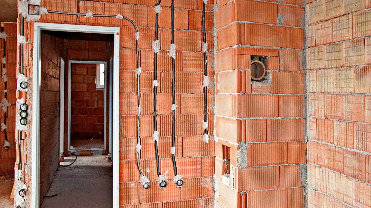 Instalacja elektryczna w budowie. Widać kable i puszki. Zastanawiasz się, ile za punkt elektryczny z kuciem?