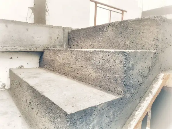 Schody betonowe w trakcie budowy. Widać surowy beton i formę, która jest szalunkiem.