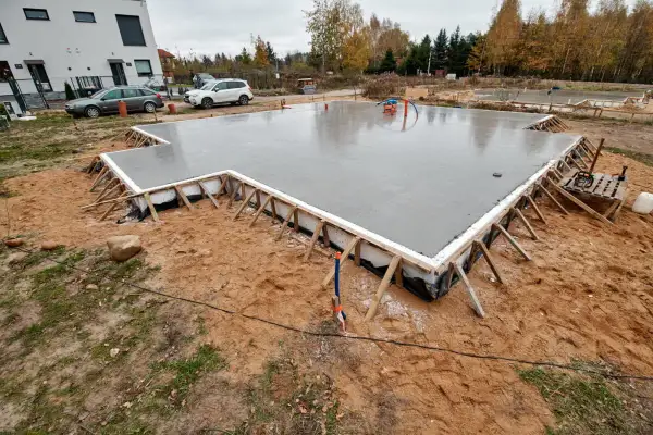 Świeżo wylany fundament pod dom szkieletowy, gotowy na kolejne etapy budowy.