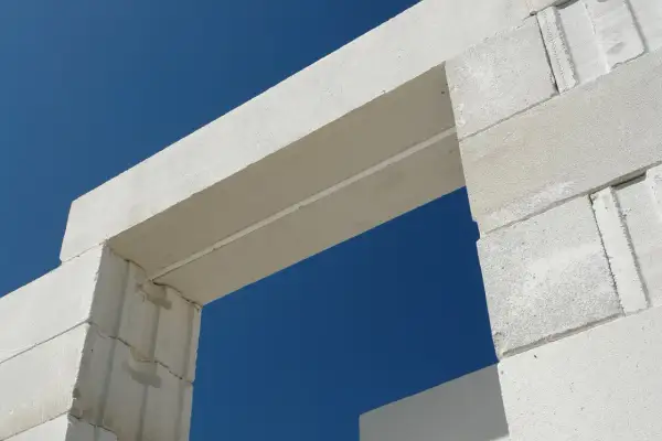 Białe nadproże nad drzwiami 90 cm, wykonane z bloczków z betonu komórkowego, na tle błękitnego nieba.