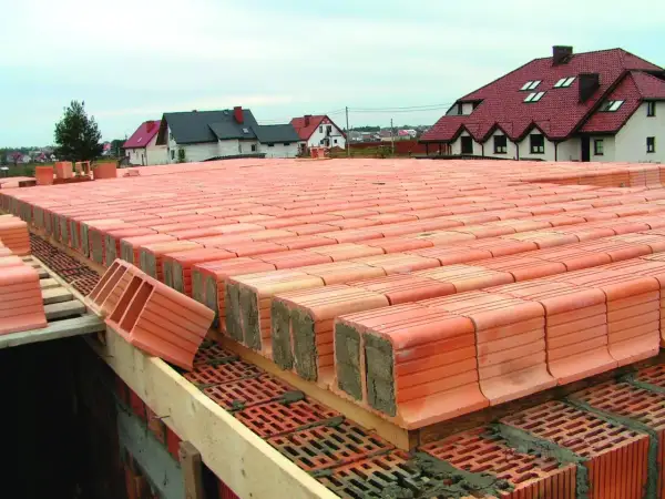 Budowa stropu Akermana z pustaków ceramicznych. Widać rzędy pustaków przygotowanych do ułożenia, tworzące solidną konstrukcję.